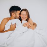 Imagen: Pareja feliz disfrutando de intimidad y conexión en la cama.
